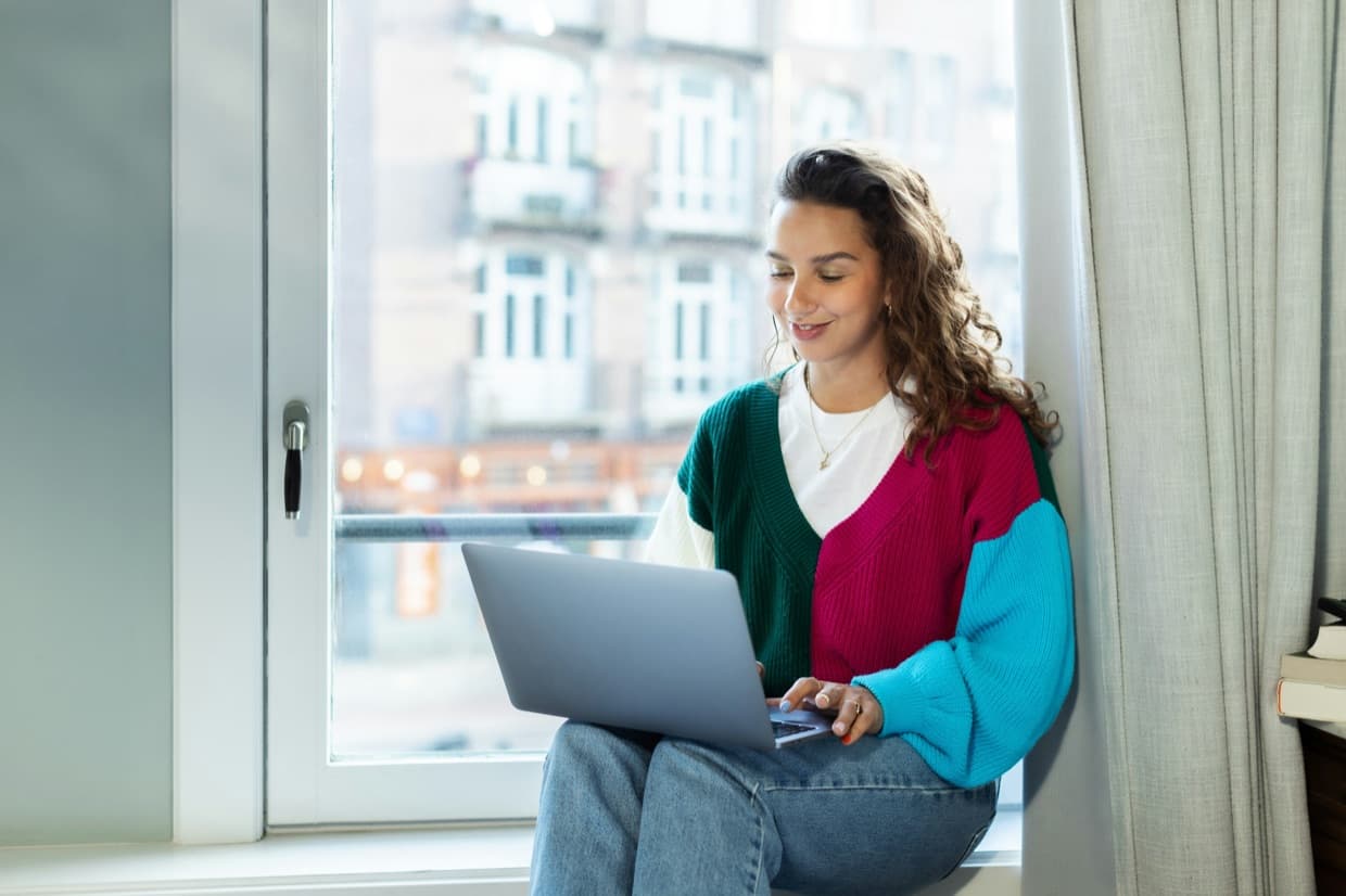 A person working at a laptop in a home office